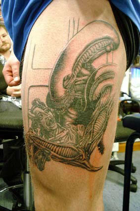 Alien upper arm tattoo